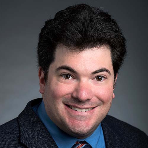 Associate professor Kenneth Strazzeri in a black suit