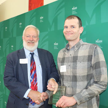 Two professors smile for an award photo