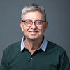 GM faculty Wassim Masri wears a green sweater and cool glasses